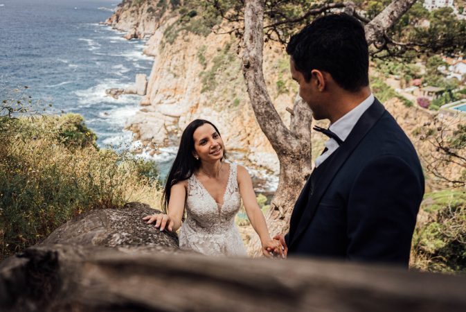 Postboda. Recién casados en el amanecer, vestidos de novios en la playa. Cola de vestido de novia. Costa brava España.